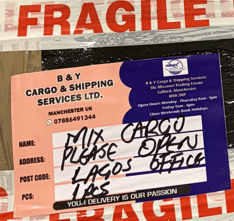 B&Y Cargo shipping label on a packed parcel bound for Lagos